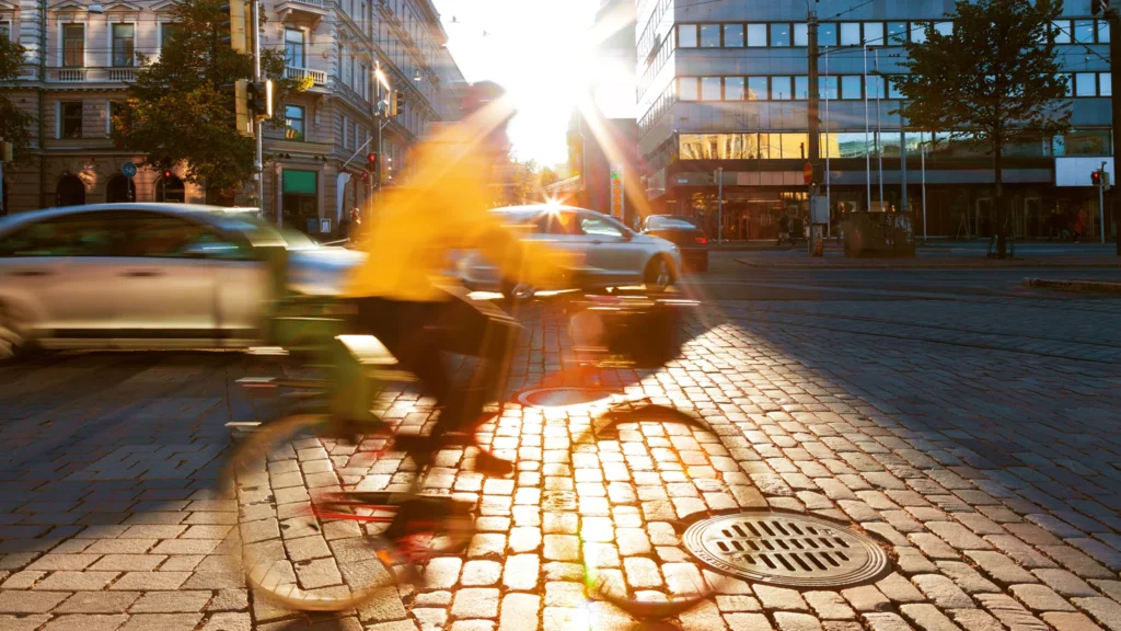 Pyöräilijä vauhdissa aurinkoisessa kaupungissa.