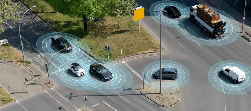 Risteysalueella ajavia ajoneuvoja, jotka havainnoivat ympäristöään ja vaihtavat tietoa.